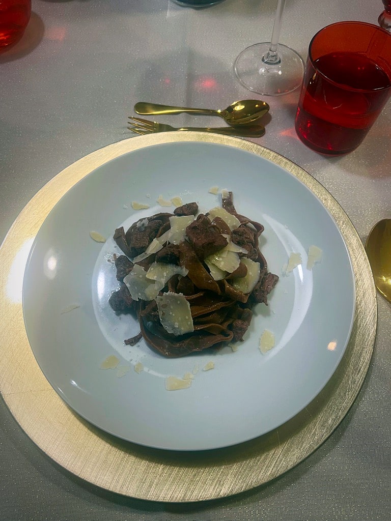 piatto di pasta al cioccolato con cinghiale e grana